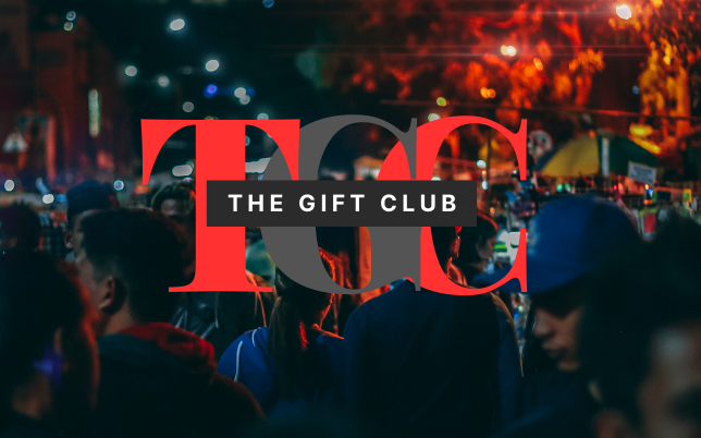 The Gift Club’s logo sits on top of a busy background of a crowded outdoor evening event.
